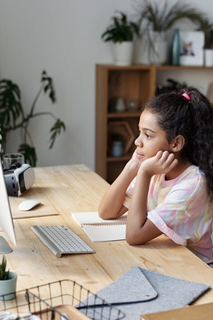 Girl in Pink Shirt Sitting by the Table