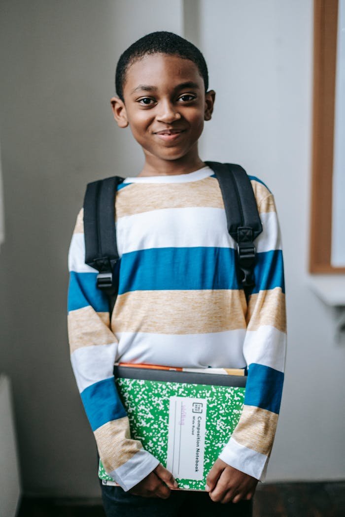 Smiling black child standing in classroom and looking at camera